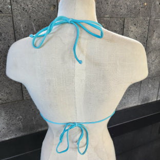Geometric patterned bikini on a mannequin against a tiled floor background